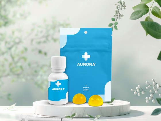 A bottle of Aurora cannabis oil and cannabis gummies along with its bag resting on a marble pedestal