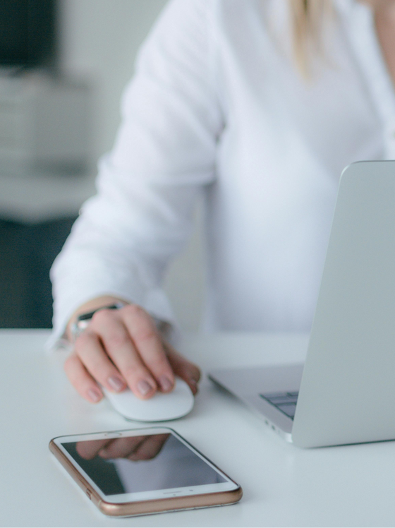 A woman with a laptop and a phone, ready to assist patients